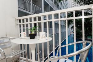 ein Balkon mit Tisch und Stühlen und ein Pool in der Unterkunft Shore residences tower D Staycation near Sm moa in Manila