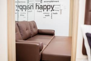 ein braunes Ledersofa in einem Zimmer mit einer Wand in der Unterkunft Shore residences tower D Staycation near Sm moa in Manila