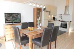 Un comedor con mesa y sillas de madera. en "Ferienhaus I - Hof Westensee", en Grömitz