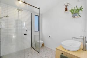 a bathroom with a shower and a sink and a toilet at Hannah's Bay Hideaway in Rotorua +12 photos