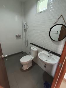 a bathroom with a white toilet and a sink at Good Nine Resort in Ban Lam Kaen