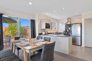 a kitchen and living room with a wooden table and chairs at Top Spot Rotorua in Rotorua