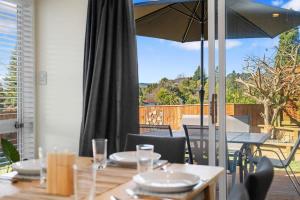 a dining table with an umbrella on a patio at Top Spot Rotorua in Rotorua