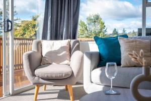 a living room with two chairs and a wine glass at Top Spot Rotorua in Rotorua