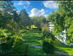 ein Garten mit grünem Gras und Bäumen und ein Gebäude in der Unterkunft BonnJour - 7 Lounge Apartment in Bonn