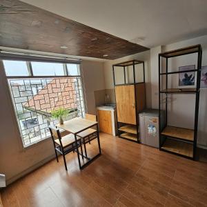 a room with a table and a window and a kitchen at KAT Home in Hanoi
