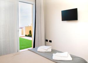 een slaapkamer met een bed met twee witte handdoeken erop bij The Blue Tajinaste in Caleta De Fuste