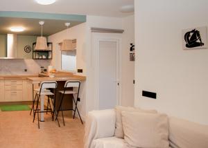 een woonkamer en keuken met een bank en een tafel bij The Blue Tajinaste in Caleta De Fuste