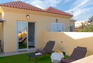 een patio met 2 stoelen en een tafel bij The Blue Tajinaste in Caleta De Fuste