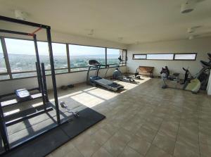 a gym with several exercise equipment in a room with windows at Disfruta Edificio Eduardo Abaro2Hab-2Baño-1 Estac in Calama