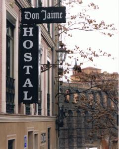 una señal para un restaurante al lado de un edificio en Hostal Don Jaime I y II, en Segovia