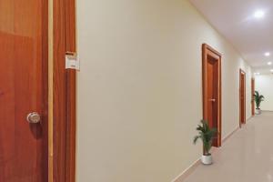 an empty hallway with a door and a potted plant at Townhouse Ragas Grand in Hyderabad +26 photos