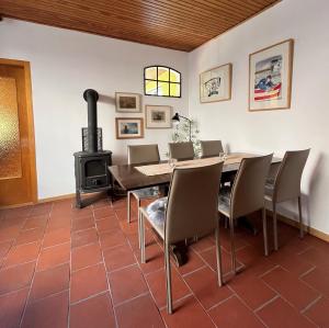 a dining room with a table and a wood stove at Ferienhaus Sprottenfang in Eckernförde