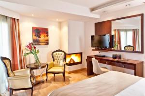 a hotel room with a bed and a desk and a fireplace at Kalavrita Canyon Hotel & Spa in Kalavrita
