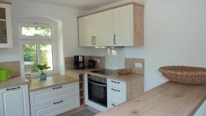 une cuisine avec des armoires blanches et un comptoir en bois dans l'établissement Ferienwohnung Am Ochsenweg, à Hüsby