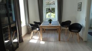 une salle à manger avec une table et quatre chaises dans l'établissement Ferienwohnung Am Ochsenweg, à Hüsby