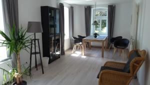 un salon avec une table et des chaises dans l'établissement Ferienwohnung Am Ochsenweg, à Hüsby 7 autres photos