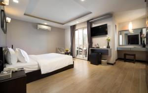a hotel room with a bed and a television at F L G Hotel in Phnom Penh