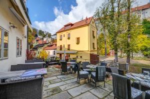 a patio with tables and chairs and a yellow building at Hotel Edward Kelly in Český Krumlov