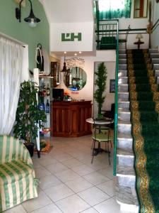 a living room with a staircase and a table and a kitchen at Lungomare Hotel in Marina di Cecina