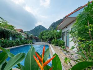 a resort swimming pool with mountains in the background at Hang Mua Holiday Homestay - Trang An in Ninh Binh
