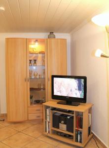 a television sitting on a stand in a room at Kleiner Bungalow in Grömitz