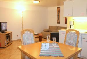 a kitchen and living room with a table and chairs at Kleiner Bungalow in Grömitz