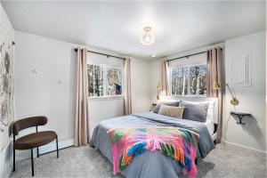 a bedroom with a bed and a chair and windows at Lux 4br Cabin W Hot Tub & Patio in Bailey