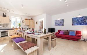 a kitchen and living room with a table and a red couch at Gorgeous sea-view VillaSol with pool & BBQ in Zagorje