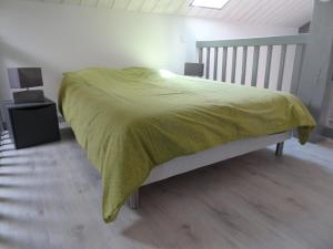 a bedroom with a bed with a yellow blanket on it at La Pointe D'Yvoire in Yvoire