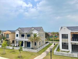 a row of houses with a palm tree at Biệt thự 4 Phòng Ngủ Novaworld Phan Thiết in Bình Tú