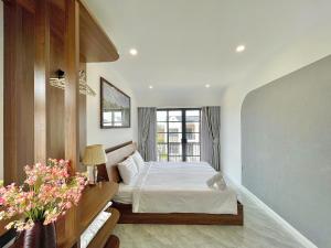 a white bedroom with a bed and a window at Biệt thự 4 Phòng Ngủ Novaworld Phan Thiết in Bình Tú