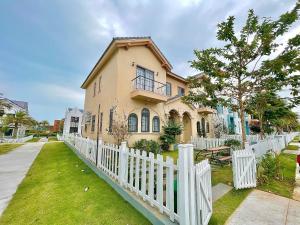 a white fence in front of a house at Biệt thự 4 Phòng Ngủ Novaworld Phan Thiết in Bình Tú