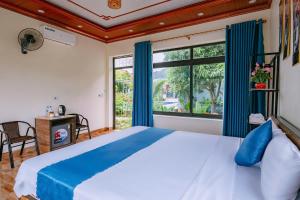a bedroom with a large bed and a large window at Hang Mua Holiday Homestay - Trang An in Ninh Binh