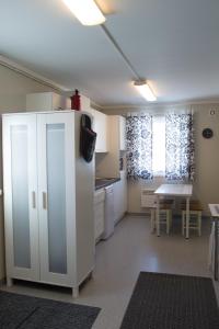 a kitchen with a white refrigerator and a table at Haltinmaa Cottages in Kilpisjärvi