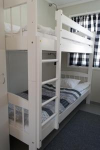 two white bunk beds in a room with a bed at Haltinmaa Cottages in Kilpisjärvi