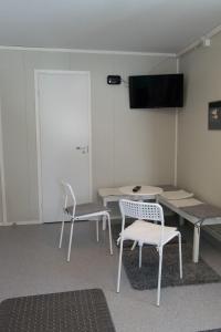 キルピスヤルヴィにあるHaltinmaa Cottagesの椅子2脚、テーブル、テレビが備わる客室です。