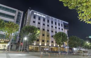 大邱Hound Hotel DaeGu的晚上，建筑物顶部有标志