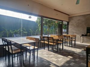 a dining room with tables and chairs and large windows at Hang Mua Holiday Homestay - Trang An in Ninh Binh
