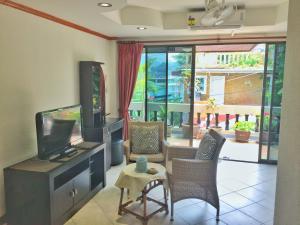 sala de estar con TV de pantalla plana y sillas en Blue Sky Residence, en Patong Beach