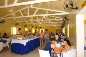 a group of people sitting at tables in a restaurant at Hotel Mar in Caraguatatuba