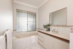 a white bathroom with a tub and a sink at Peppy Tree Bungalow in Dunsborough +12 photos