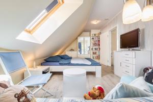 ツィングストにあるHuus Jetteの小さな屋根裏のベッドルーム(ベッド1台、テレビ付) +12枚の写真