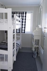 a room with three bunk beds and a window at Haltinmaa Cottages in Kilpisjärvi