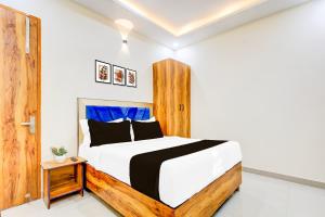 a bedroom with a bed with a wooden headboard at Hotel O Blu Plaza in Gurgaon