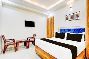 a bedroom with a bed and a table and chairs at Hotel O Blu Plaza in Gurgaon