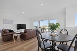 a living room with a table and a couch at 66 Neighbour Ave Goolwa - Linen Provided in Goolwa South