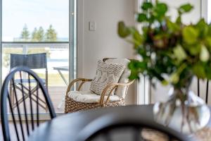 a room with a chair and a table with a vase at 66 Neighbour Ave Goolwa - Linen Provided in Goolwa South
