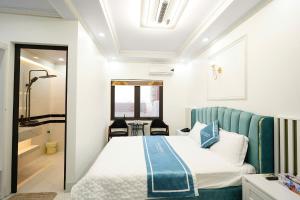 a bedroom with a bed with a blue headboard at Legacy Hotel in Kỳ Vĩ +36 photos