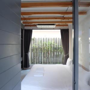 a bedroom with a bed and a window with trees at Huahin House Premium in Hua Hin +25 photos
